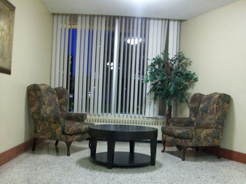 a living room with chairs and a table and a window